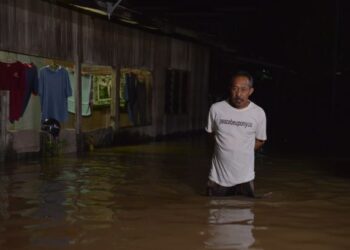 SEORANG penduduk Kampung Binjai di Chendering, Kuala Terengganu melihat kediamannya dinaiki air akibat banjir kilat malam tadi.-UTUSAN/PUQTRA HAIRRY ROSLI