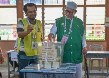 ABDUL Hadi Awang melaksanakan tanggungjawab mengundi di Pusat Mengundi Sekolah Kebangsaan Teluk Kalong. - UTUSAN/PUQTRA HAIRRY