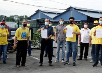 AZRUL Suhadi Ahmad Mokhtar (depan, dua dari kanan) menunjukkan memorandum mendesak pihak berkuasa membuat pemeriksaan terhadap ramai warga asing yang digajikan sebagai pekerja di Pasar Borong Ipoh, hari ini. - FOTO/ZULFACHRI ZULKIFLI