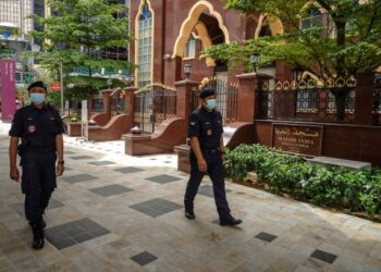 ANGGOTA polis meronda di kawasan Masjid India di Kuala Lumpur. - UTUSAN/FARIZ RUSADIO