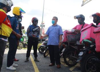 FUAD Alias memberi penerangan tentang manfaat caruman di bawah Program SKSPS Perkeso kepada penghantar makanan di Senawang, Seremban hari ini. - FOTO/MUHAMMAD IZZAT TERMIZIE