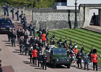 ANGGOTA kerabat diraja berjalan mengiringi kenderaan yang membawa keranda Putera Philip ke St George Chapel di Istana Windsor. - AFP