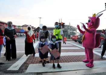 MASKOT Pinkfong menyambut kedatangan murid-murid pada hari pertama sesi persekolahan 2021 secara bersemuka di SK (P) Sultan Ibrahim, Johor Bahru, Johor, semalam. – UTUSAN/RAJA JAAFAR ALI