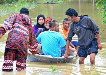 ANGGOTA penyelamat membantu penduduk berpindah ke tempat lebih selamat dengan menaiki sampan di Kampung Teluk Mahang, Paya Besar, Pahang pada 4 Januari lalu. - UTUSAN/SHAIKH AHMAD RAZIF