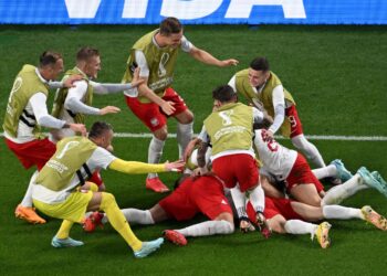 PEMAIN-pemain Poland meraikan jaringan Robert Lewandowski (terlindung) menentang Arab Saudi, semalam. Poland menang 2-0. - AFP