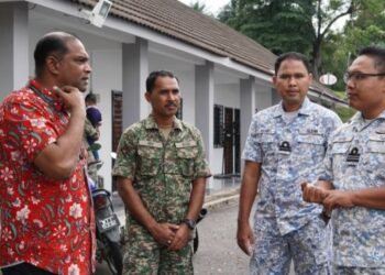 R. RAMANAN (kiri) berbual dengan anggota tentera yang selesai membuang undi awal di Kem Tentera Paya Jaras, Sungai Buloh, hari ini.