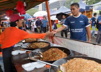 RADZI Jidin bermesra dengan peniaga ketika mengadakan kempen 'walkabout' di Pasar Tani Presint 2 Putrajaya. - UTUSAN/FAISOL MUSTAFA