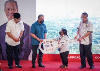 MUHYIDDIN Yassin menyampaikan replika kunci kepada salah seorang penghuni, L. Mageswary yang turut disaksikan oleh Menteri Wilayah Persekutuan, Tan Sri Annuar Musa (kiri) sempena Majlis Penyerahan Kunci Rumah kepada Penerima Unit Baru Projek Residensi RazakMas2 di Bandar Tun Razak, Kuala Lumpur hari ini. - FOTO/MUHAMAD IQBAL ROSLI