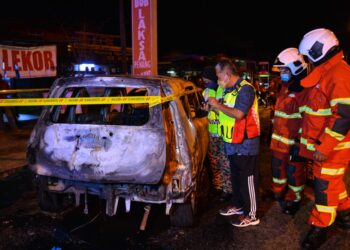 ANGGOTA bomba memeriksa Perodua Alza milik Mohd. Azizi Jaafar yang terbakar terbakar di Jalan Kuala Terengganu-Kuala Berang berhampiran Kampung Wakaf Beruas di Kuala Terengganu, malam ini. - UTUSAN/PUQTRA HAIRRY ROSLI