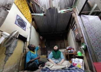 MARZUKI Abdul Manaf (kiri) dan Aida Ahmad melihat keadaan atap zink yang reput dan bocor di rumah mereka di Kampung Baru Jalan Tokong India, Kamunting dekat Taiping, Perak. - UTUSAN/ASLIZA MUSA