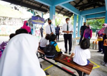 RADZI Jidin berbual dengan tenaga pengajar SK Bandar Sri Damansara 3 selepas meninjau perjalanan ujian saringan Covid-19 dalam kalangan murid-murid semalam.