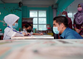 Menteri Pendidikan, Datuk Radzi Jidin berbual dengan seorang murid semasa membuat lawatan mengejut di sebuah sekolah di Putrajaya, semalam. – Gambar Facebook Kementerian Pendidikan Malaysia