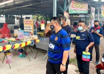 TUANKU Syed Faizuddin Putra Jamalullail membawa bekas makanan semasa membeli juadah di bazar Mata Ayer, Perlis, semalam.