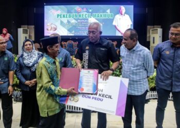 Mahdzir Khalid  menyampaikan Anugerah Tokoh Pekebun Kecil kepada penerima pada Majlis Pekebun Kecil Makmur Peringkat Negeri Kedah Tahun 2022 di Institut Kemahiran Belia Negara (IKBN) Naka di Padang Terap semalam. – UTUSAN/ SHAHIR NOORDIN
