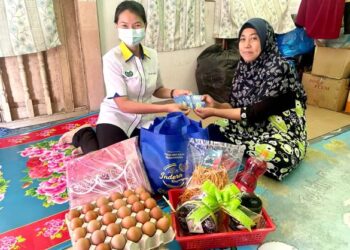 GAN Ay Ling (kiri) menyampaikan sumbangan kepada Bakriah Mohd. Abu Bakar ketika melawat rumahnya di Jalan Sekolah Derma, Kangar, Perlis, semalam. - FOTO/NAZLINA NADZARI