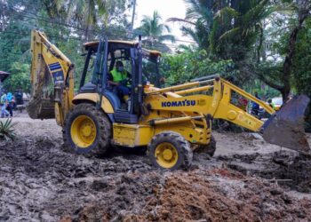 MUHAMMAD Sanusi Md. Nor membawa jentolak bagi membuang selut di rumah mangsa banjir ketika hadir program khidmat masyarakat di Kampung Batu 20 Sungai Lui, Hulu Langat, Selangor, hari ini. -UTUSAN/FARIZ RUSADIO 