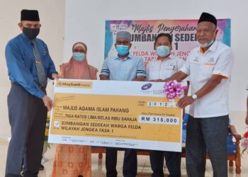 SULAIMAN Bakar (kanan) menyampaikan replika cek bernilai RM315,000 kepada Khairuddin Ismail (kiri) sambil diperhatikan oleh Ahmad Nazlan Idris (tiga dari kanan) di Felda Jengka 10 di Kuala Krau, Pahang, hari ini.