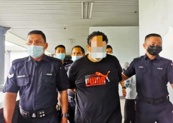 ISKANDAR Ishak diiringi anggota polis selepas dihadapkan di Mahkamah Sesyen Ayer Keroh, Melaka. - UTUSAN/DIYANATUL ATIQAH ZAKARYA