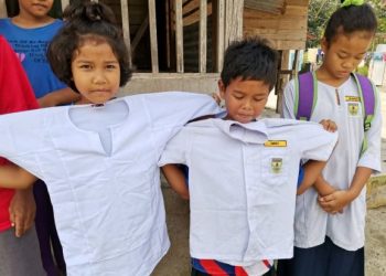 KANAK-KANAK Orang Asli menunjukkan baju sekolah lama ketika ditemui di Kampung Redang Punggor, Chenderong Balai, Pasir Salak, Perak, semalam. – FOTO/AIN SAFRE BIDIN