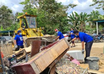 MOHD. SHAHAR Abdullah turut serta dalam kerja-kerja memindahkan barang yang musnah akibat banjir di PAKR Bukit Rangin di Kuantan, Pahang. - UTUSAN/NIK NAIZI HUSIN