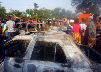 Orang ramai melihat kereta yang terbakar akibat kejadian letupan lori tangki yang menyebabkan lebih 90 orang maut di Sierra Leone. = AFP