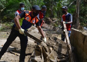 MOHD. Zahir Shari (kiri) turut sama terlibat dalam program bantuan pembersihan pasca banjir di Kampung Puom, Jelebu baru-baru ini. - UTUSAN/ZAKKINA WATI AHMAD TARMIZI