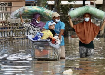 PENDUDUK meredah  banjir di Seksyen 25 Sri Muda, Shah Alam, Selangor. -UTUSAN/ZULFADHLI ZAKI