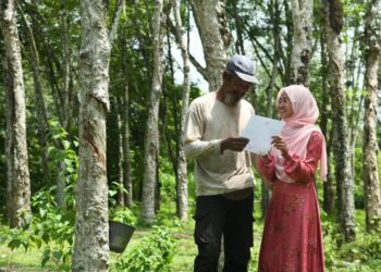 NUR Alia Maisarah menunjukkan keputusan 9A SPM  kepada ayahnya, Abdullah Ismail, 54, di  kebun getah di Kampung Kubang Perun, Chuping, Padang Besar semalam. – UTUSAN/IZLIZAN OTHMAN