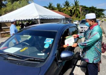 AHMAD MARZUK menyampaikan bantuan kepada salah seorang pelajar di pejabat Pusat Ahli Parlimen Pengkalan Chepa, Kelantan, hari ini. - UTUSAN/ROHANA MOHD. NAWI