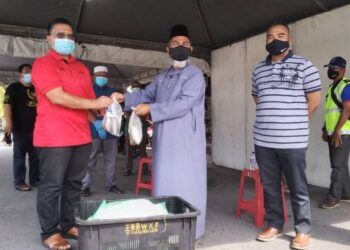 SYED Abu Hussin Hafiz Syed Abdul Fasal (tengah) menyampaikan sumbangan ikan sejuk beku kepada penduduk di Taman Berkat, Taiping, Perak hari ini. - FOTO/WAT KAMAL ABAS