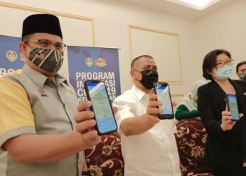 SAARANI Mohamad (tengah) menunjukkan sijil Digital MySejahtera selepas melengkapkan program imunisasi Covid-19 di PPV Stadium Indera Mulia di Ipoh hari ini. - UTUSAN ONLINE