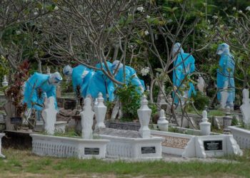 PETUGAS Jabatan Kesihatan Terengganu menguruskan pengkebumian jenazah Tun Dr. Mohamed Salleh Abas di Kuala Terengganu, semalam. – MINGGUAN/PUQTRA HAIRRY ROSLI