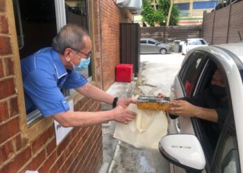 WAN Junaidi Tuanku Jaafar (kiri) menyerahkan sate yang dibeli seorang pelanggan secara pandu lalu di Al-Mizan Satay House, di Kampung Ubi, Johor Bahru, Johor. - FOTO/KHAIRUL MOHD. ALI