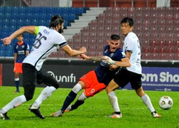 PENYERANG JDT II, Fernando Rodriguez cuba melepasi pertahanan TFC II, Masaki Watanabe dan Argzim Redzovic   dalam aksi Liga Perdana di Larkin malam ini. - UTUSAN/RAJA JAAFAR ALI