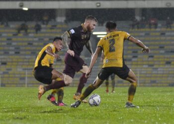 PEMAIN Terengganu FC, Lee Tuck (tengah) cuba melepasi halangan pemain Perak, Danish Haziq (kanan) dalam aksi Piala Malaysia di  Stadium Perak, Ipoh malam ini. UTUSAN/ZULFACHRI ZULKIFLI