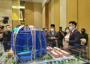 MOHD. Ali Mohd. Rustam diberikan penerangan berkenaan projek penyediaan ruang kerja global terbesar di dunia di Hotel Ames, Ayer Keroh, Melaka. - FOTO/DIYANATUL ATIQAH ZAKARYA