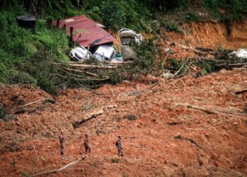 TIGA anggota bomba meninjau keadaan lokasi tanah runtuh pada hari kedua operasi mencari dan menyelamat mangsa dalam kejadian tanah runtuh di Tapak Perkhemahan Father’s Organic Farm, Jalan Batang Kali-Genting Highland di sini, hari ini. -UTUSAN/ MUHAMAD IQBAL ROSLI