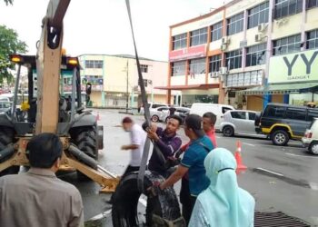 JENGKAUT digunakan untuk membawa keluar tayar lori yang dibuang ke dalam longkang berdekatan Jalan Inderapura di Jerantut, Pahang semalam.