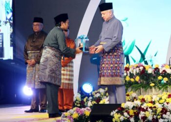 SULTAN Nazrin Muizzuddin Shah menyampaikan hadiah kepada Mohd Kamaruzaman Daud pada majlis Tilawah dan Hafazan al-Quran peringkat negeri Perak di Ipoh semalam. - UTUSAN/MUHAMAD NAZREEN SYAH MUSTHAFA