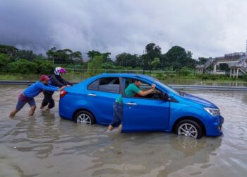 Orang ramai membantu sebuah kenderaan yang rosak akibat ditenggelami air akibat limpahan dari Sungai Damansara yang mengakibatkan jalan di Batu 3, Lebuhraya Persekutuan tidak boleh dilalui oleh kenderaan baru-baru ini. -UTUSAN/FARIZ RUSADIO