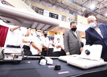 BAHARIN DIN mengiringi bekas Pengerusi TNB, Datuk Seri Mahdzir Khalid (kanan) melihat pameran TNB yang mempamerkan pelbagai peralatan elektrik berteknologi tinggi.