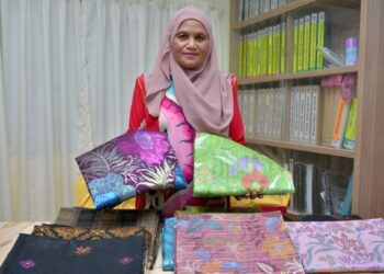 DALIMAH Awang menunjukkan pelbagai rekaan songket yang dihasilkannya di bawah jenama Songket PC di Kampung Gong Baru, Kuala Nerus, Terengganu, baru-baru ini.