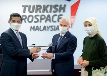 TEMEL  Kotil menyampaikan cenderamata kepada Mohammad  Azmin Ali sambil disaksikan oleh Merve Kavakci pada majlis perasmian pejabat Turkish Aerospace di Cyberjaya, kelmarin.