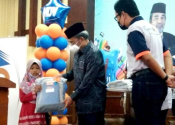 TAJUDDIN Abdul Rahman menyampaikan kelengkapan sekolah kepada murid pada Program Sejambak Kasih 'Back-to-School' di Kampung Gajah hari ini. - FOTO/AIN SAFRE BIDIN