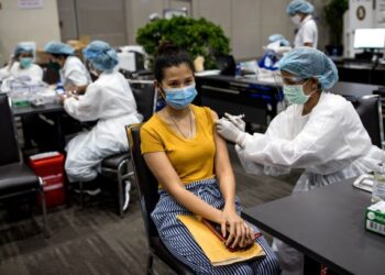 SEORANG wanita menerima suntikan vaksin Covid-19 di sebuah pusat vaksinasi di Bangkok. - AFP