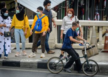 PENDUDUK memakai pelitup muka di tempat awam selepas kerajaan melaksanakan sekatan baharu di Thailand dalam usaha mengekang pandemik Covid-19. - AFP