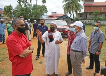 Ahli Parlimen Langkawi, Tun Dr. Mahathir Mohamad berbual dengan seorang wakil penduduk di perkampungan Bukit Malut, Pulau Langkawi, semalam semasa meninjau ke penempatan tersebut yang kebanyakannya dihuni penduduk berasal dari Myanmar. – UTUSAN/SHAHIR NOORDIN