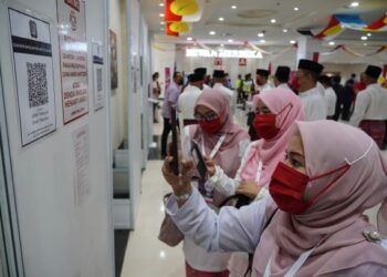 SEBAHAGIAN perwakilan Puteri UMNO mengimbas aplikasi MySejahtera pada Perhimpunan Agung UMNO 2020 di Dewan Merdeka, Pusat Dagangan Dunia (WTC) Kuala Lumpur. - UTUSAN /AMIR KHALID