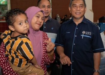 KASIM Mansor (kanan) beramah mesra dengan ibu bapa pelajar ketika membuat tinjauan kemasukan penuntut baharu di UMS, semalam.