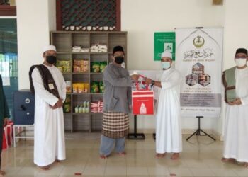 HELMI Zaifura Abdul Rahman (kiri) menyerahkan kit sumbangan sebagai simbolik kepada wakil pelajar, Zulridzuan Zainudin di Masjid al-Mursyidin, Kampus Sultan Azlan Shah, UPSI, Tanjung Malim, Perak.